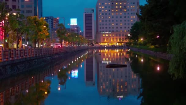 Las Luces Ciudad Reflejan Agua Del Foso Mientras Ambulancia Pasa — Vídeo de stock