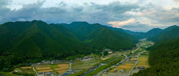 stock image Golden wheat and green rice fields in mountain village, panoramic aerial view. High quality photo