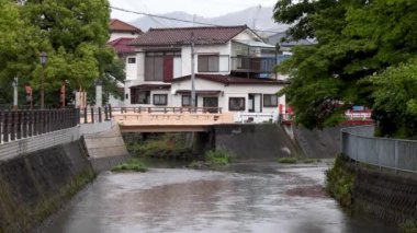 Yağmurlu bir günde, Japon mahallesinde su asfalt nehirden ev ev akar. Yüksek kalite 4k görüntü