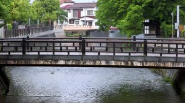 Yağmurlu bir günde Japon kasabasında akan suyun üzerindeki boş köprü. Yüksek kalite 4k görüntü