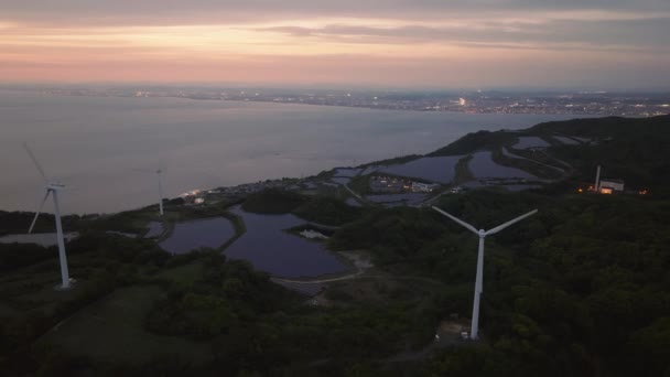 Alacakaranlıkta Uzak Şehirden Gelen Işıklarla Rüzgar Türbinlerinin Güneş Panellerinin Havadan — Stok video