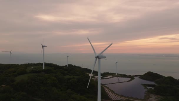 日没時に風力タービンと太陽光パネルの空中上昇と後退 高品質4K映像 — ストック動画