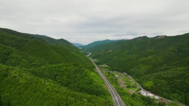 緑に覆われた山々をまっすぐ高速道路を飛んでいます 高品質4K映像 — ストック動画