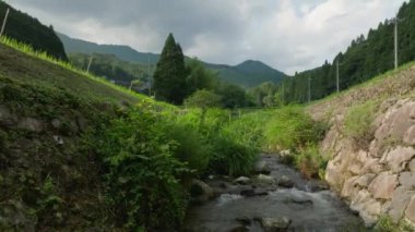 Nehirden akan suyun üzerinde pirinç tarlaları ve dağ köyleri yükseliyor. Yüksek kalite 4k görüntü