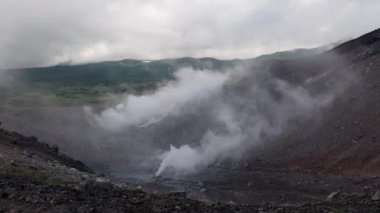 Bulutlu bir günde volkanik dağdaki fümerollerden gaz ve buhar salınımı. Yüksek kalite 4k görüntü