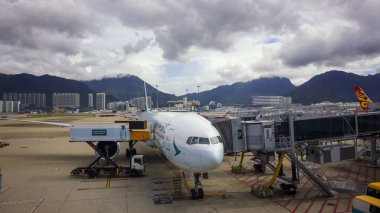 Hong Kong, 8 Eylül 2023, Cathay Pacific yolcu uçağı bulutlu bir günde yolcu kapısında. Yüksek kalite fotoğraf