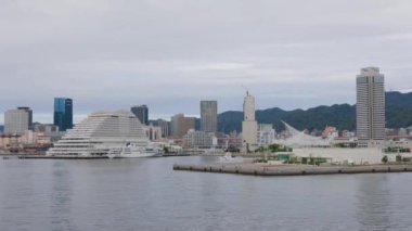 Kobe, Japonya - 23 Eylül 2023: Sahil Güvenlik teknesi Sannomiya kulesi binalarından geçiyor. Yüksek kalite 4k görüntü