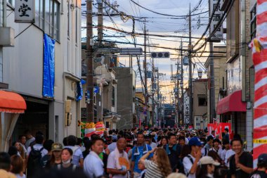 Kishiwada, Japonya - 17 Eylül 2023: Küçük kasaba festivalinde kalabalık bir caddenin üzerinde gün batımı parlıyor. Yüksek kalite fotoğraf