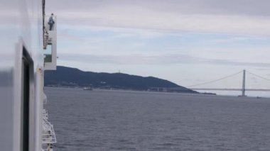 Feribot bulutlu bir günde Awaji Adası 'ndan Akashi asma köprüsüne dönüyor. Yüksek kalite 4k görüntü