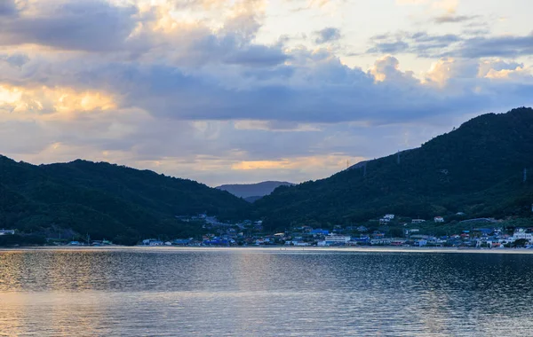 Coastal village by calm water and mountains on Shodo Island at sunset. High quality photo