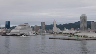 Kobe, Japonya - 23 Eylül 2023 Japonya Sahil Güvenlik teknesi limandan ikonik binalarla yola çıktı. Yüksek kalite 4k görüntü