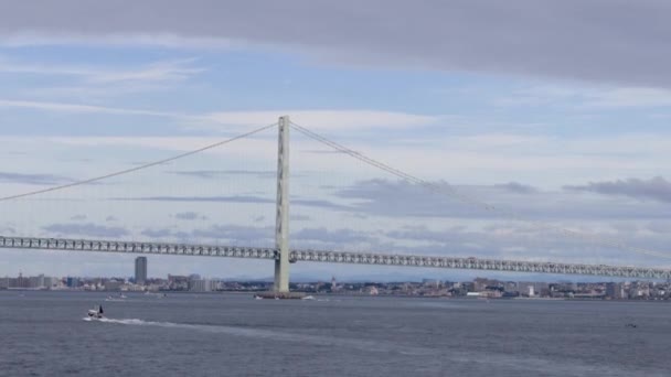 Небольшая Рекреационная Лодка Плывет Возвышающемуся Подвесному Мосту Городу Облачный День — стоковое видео