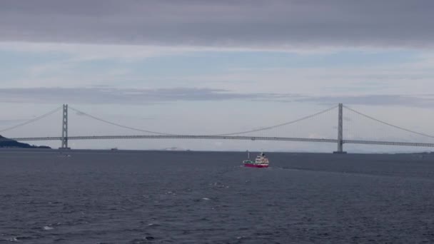 Mały Statek Płynie Spokojnych Wodach Przez Most Akashikakyo Pochmurny Dzień — Wideo stockowe