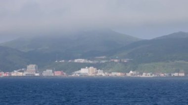 Japonya 'nın Hokkaido kentindeki Rebun Adası' nda yüksek sis tabakası altında sakin mavi su ve kıyı kasabası. Yüksek kalite 4k görüntü