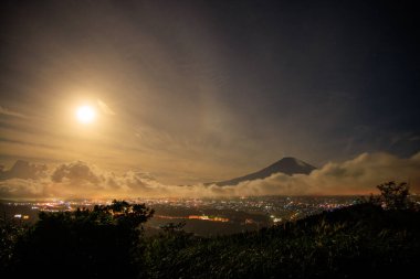 Süper Ay bulutların ve şehrin üzerinde parlıyor. Fuji. Yüksek kalite fotoğraf