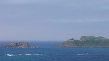 Güneşli bir günde Japonya 'nın Hokkaido kentindeki Rebun Adası' ndaki Cape Sukoton 'daki kayalık adalardan gelgit akıntısı akar. Yüksek kalite 4k görüntü