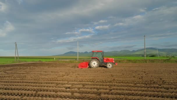Leuchtend Roter Traktor Auf Gepflügten Reihen Auf Einem Unbepflanzten Feld — Stockvideo