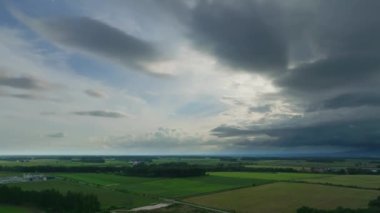 Hokkaido yazında kara yağmur bulutları yaklaşırken yeşil tarlaların havadan görünüşü. Yüksek kalite 4k görüntü