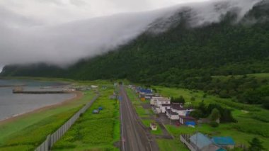 Japonya 'nın Hokkaido kentindeki orman dağlarında sis çökerken kıyı evlerinin orada yükseliyor. Yüksek kalite 4k görüntü