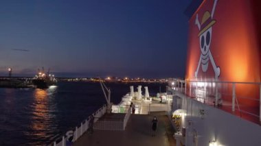 Hokkaido, Japonya - 31 Ağustos 2023: Feribot gece demir alırken anime kafatası ve bacadaki çapraz kemikler. Yüksek kalite 4k görüntü