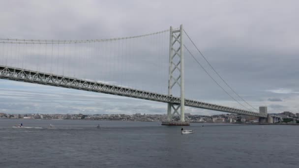 タワー張りの吊り橋の下を航行する小さなボートのゆっくりとした動きのビュー 高品質の4K映像 — ストック動画