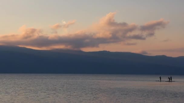 Tres Tablas Paddle Siluetas Distantes Tranquilo Lago Montaña Atardecer Imágenes — Vídeos de Stock