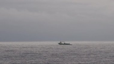 Yalnız küçük tekne Hokkaido açıklarında Japon Denizi 'nde şafak vakti açık okyanus sularında balık tutuyor. Yüksek kalite 4k görüntü