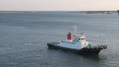 Tomakomai, Japonya - 31 Ağustos 2023: sakin liman suyunda ağır çekimde ağır çekimde römorkör römorkörü boşta. Yüksek kalite 4k görüntü