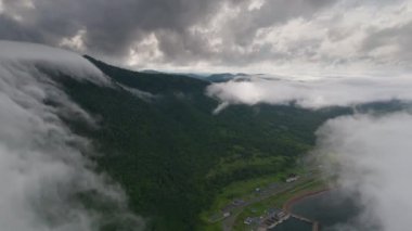 Japonya 'nın Hokkaido kentindeki yemyeşil yemyeşil arazide alçak bulutlar ve sisli kıyı topluluklarına dalın. Yüksek kalite 4k görüntü