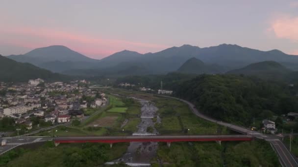 日の出に小さな町や緑の山々で川を飛んでいる 高品質の4K映像 — ストック動画
