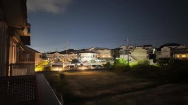 Bulutlar üzerimizde hareket ederken, gece yoğun yoldaki banliyö evlerinin zaman atlamalı tepsisi. Yüksek kalite 4k görüntü