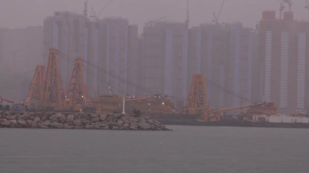 霧の中のアパートの建物によるクレーンや建設機材によるセーリング 高品質の4K映像 — ストック動画