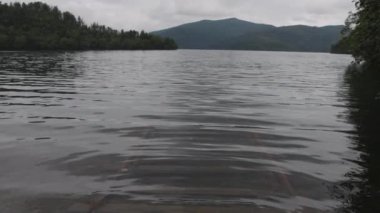 Orman dağlarındaki sakin gölde suyun altında raylar var. Yüksek kalite 4k görüntü