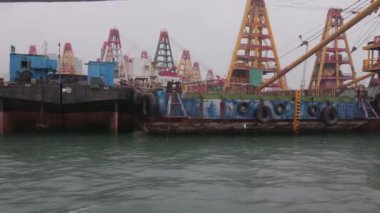 Yağmurlu ve gri havada mavnalarla ve yüzen vinçlerle yelken açıyorlar. Yüksek kalite 4k görüntü