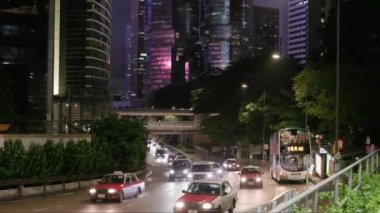 Hong Kong - 8 Ağustos 2023: Arabalar ve taksi trafiği gece geniş yollarda otobüs durağından geçer. Yüksek kalite 4k görüntü