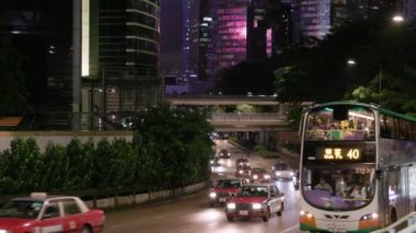 Hong Kong - 8 Ağustos 2023: otobüs, taksiler ve arabalar gece boyunca geniş yolda ilerliyorlar. Yüksek kalite 4k görüntü