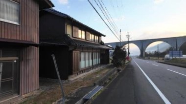 Geleneksel Japon evinin önünden geçmek ve güneş doğarken kemerli köprü. Yüksek kalite 4k görüntü
