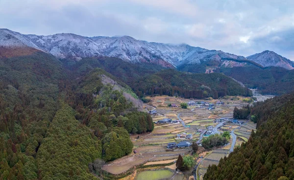 Pemandangan Udara Dari Sawah Bertingkat Desa Kecil Oleh Pegunungan Bersalju Stok Gambar