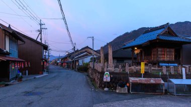 Quiet street with traditional wooden houses in Japanese village at sunset. High quality photo clipart