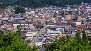 Takayama, Japan - August 4, 2024: Hilltop view of buildings and main street in central Takayama city on sunny summer day. High quality photo clipart