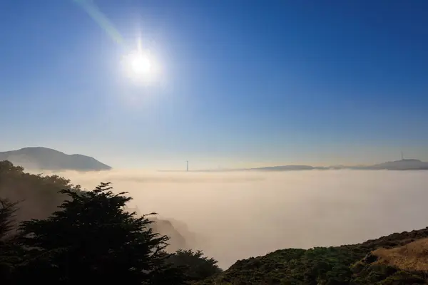 Parlak güneş ve mavi gökyüzü sisli Golden Gate Köprüsü ve şehir mesafesinde. Yüksek kalite fotoğraf