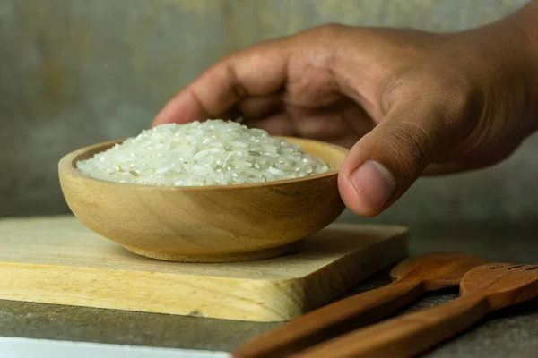 木製のスプーンとフォークで木製のボウルに生米 乾燥米や炊かれていない米 — ストック写真
