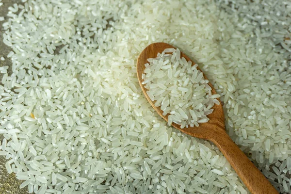 top angle view of raw rice and wooden spoon. dry rice or uncooked rice.