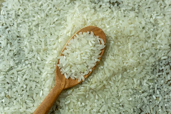 生米和木制勺子的顶角视图 干米或未煮熟的米 — 图库照片
