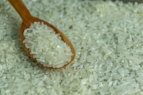 生米と木のスプーンの上からの眺め 乾燥米や炊かれていない米 — ストック写真
