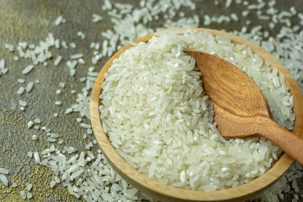 木製のスプーンとフォークで木製のボウルに生米 乾燥米や炊かれていない米 — ストック写真
