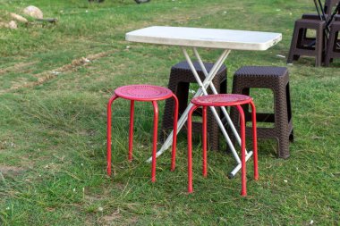 Taşınabilir piknik koltuğu ve masa. Piknik sandalyesi ve çimenlikteki masa. Açık kahve dükkanı kavramı.