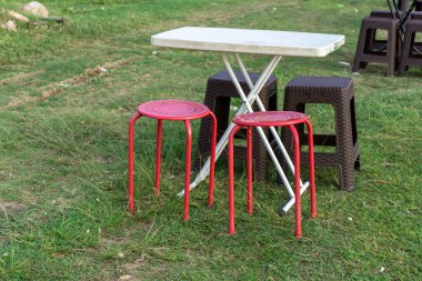 Taşınabilir piknik koltuğu ve masa. Piknik sandalyesi ve çimenlikteki masa. Açık kahve dükkanı kavramı.