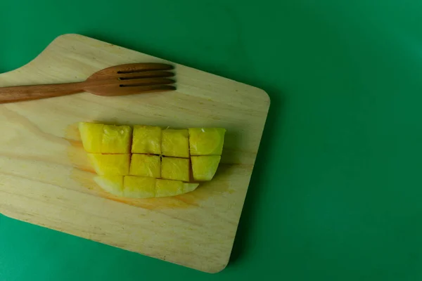 木盘上的黄瓜片 绿色背景下的黄色西瓜片 — 图库照片