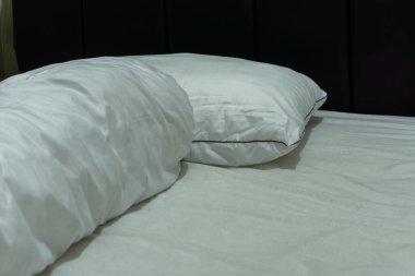 Beyaz yastıklı ve destekli rahat bir yatak. Yatak odasını kapatın.